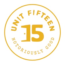 Unit Fifteen cannabis brand logo with gold “15” and circular text on a white background